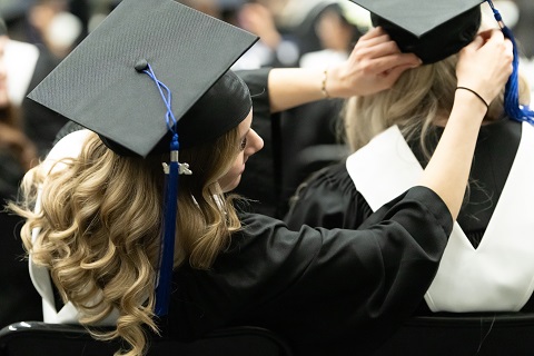 graduate fixing anothers hat